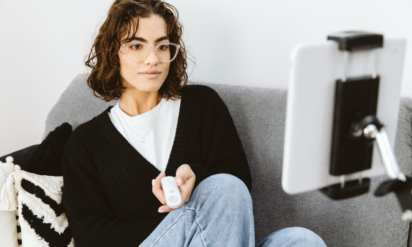 Person mit tolino flip (Fernbedienung) in der Hand & tolino eReader in einer Halterung